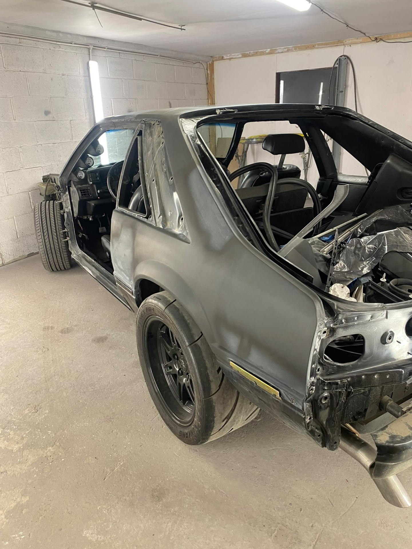 Before — Stripped back to bare panels and prepared in primer, then refinished to a gloss black show-quality shine.
